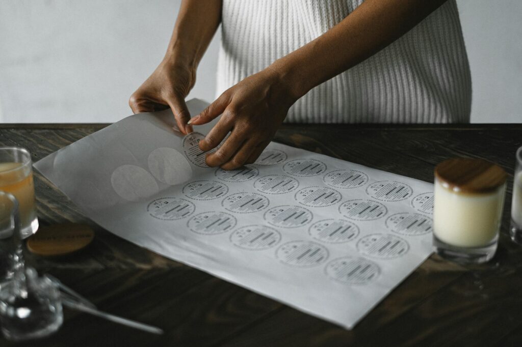 A detail shot of an artisan preparing craft stickers in a cozy workshop setting.